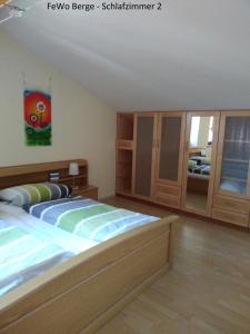 a bedroom with a large bed and wooden cabinets at Haus Ellerbeck in Bodenmais
