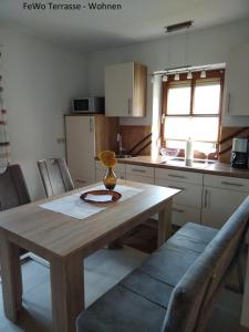 a kitchen with a wooden table with chairs and a table and a table at Haus Ellerbeck in Bodenmais +18 photos
