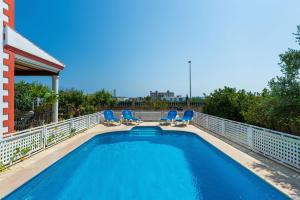 a swimming pool on a balcony with blue chairs at Villa Tortugas, 5 min ibiza City in Ibiza Town