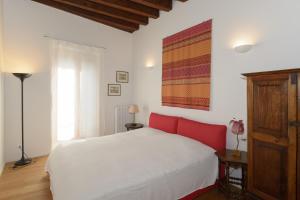 Schlafzimmer mit einem weißen Bett und einem roten Kopfteil in der Unterkunft Ca' Zacco in Venedig