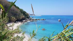 a view of a beach with rocks in the water at Villino Eleonora in Parghelia