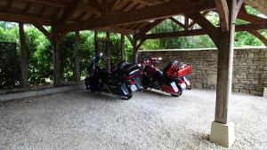 ein paar Motorräder, die unter einem Gebäude geparkt sind. in der Unterkunft Le Mas de Laché in Caylus