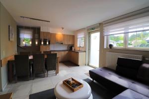 a living room and kitchen with a couch and a table at Stefjes Holiday Home in Dilsen-Stokkem