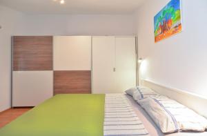 sypialnia z zielonym łóżkiem i szafką w obiekcie Apartment Vesna 1642 w Puli