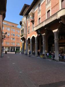 una calle de la ciudad con edificios y gente sentada en sillas en Appartamento Mosaico 22161, en Rovereto