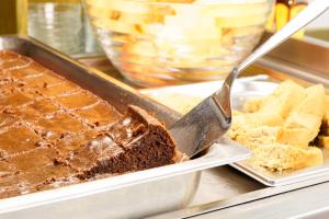 a piece of chocolate cake on a plate with a spatula at Jugendherberge Wien - Myrthengasse in Vienna