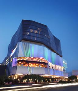 PO Hotel Semarang في سيمارانغ: مبنى زجاجي كبير عليه قزاز