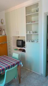 eine kleine Küche mit einem Tisch und einer Mikrowelle in der Unterkunft Appartamento in paese a Santa Teresa in Santa Teresa Gallura