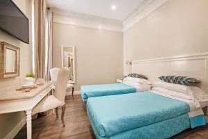 une chambre d'hôtel avec deux lits et un bureau dans l'établissement Le Stanze Di Elle, à Rome
