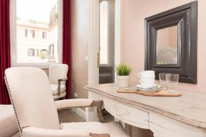 une salle à manger avec une table, des chaises et un miroir dans l'établissement Le Stanze Di Elle, à Rome