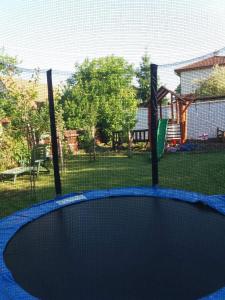 a trampoline in a yard with a fence at Aliz Apartman in Nyíregyháza
