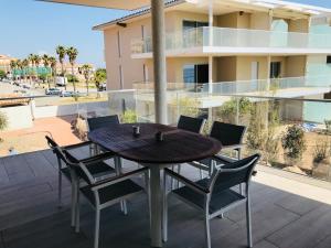 サリ・ソランザラにあるCorsicacasa Appartement Sur La Mer Port De Solenzaraの建物の景色を望むバルコニー(テーブル、椅子付)