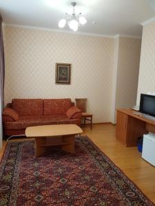 a living room with a couch and a coffee table at Гостиница "Алтын Орда" in Astana