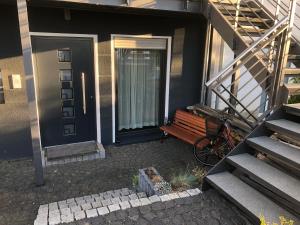 eine Tür zu einem Haus mit einer Bank daneben. in der Unterkunft Ferienwohnung Mainz in Mainz