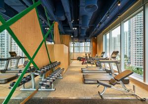 - une salle de sport avec des rangées d'équipements d'exercice dans un bâtiment dans l'établissement Hotel COZi Wetland, à Hong Kong