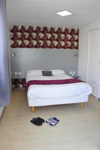 a bedroom with a large bed with underwear on the floor at Hôtel de la baie de Paimpol in Ploubazlanec