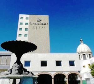 um grande edifício com uma estátua em frente em Hotel San Francisco Irapuato Business Class em Irapuato