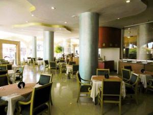 Un comedor con mesas y sillas en un restaurante. en Hotel San Francisco Irapuato Business Class, en Irapuato