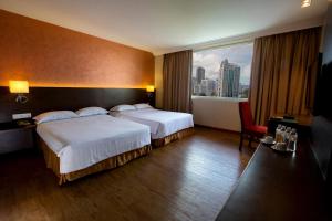 a hotel room with two beds and a large window at Hotel Malaysia in George Town