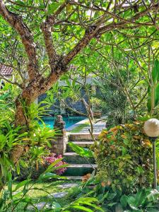 un jardin avec des escaliers, des plantes et un arbre dans l'établissement Ayu Bungalow 2, à Ubud