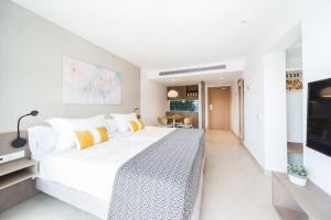 a bedroom with a large white bed and a table at Inturotel Esmeralda Park in Cala d´Or