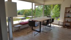a table and chairs in a room with a large window at Hamerenne in Rochefort
