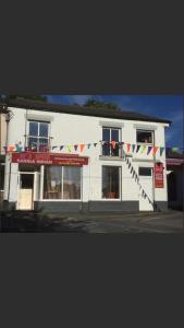 a white building with flags in front of it at Ingleton M'S Apartment in Ingleton