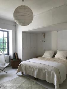 a bedroom with a large bed and a large pendant light at "Côté cour, côté jardin" in Bonnes