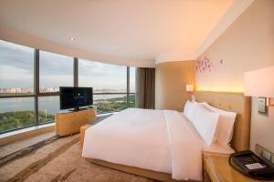 a hotel room with a bed and a television at Pullman Linyi Lushang in Linyi