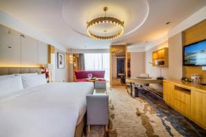 a hotel room with a large bed and a living room at Pullman Linyi Lushang in Linyi