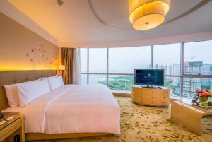 a hotel room with a bed and a television at Pullman Linyi Lushang in Linyi