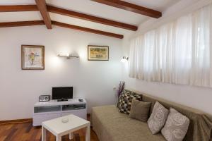 a living room with a couch and a tv at Apartments Green Scenic in Dubrovnik