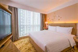 een hotelkamer met een groot bed en een groot raam bij Pullman Linyi Lushang in Linyi