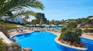 a pool with chairs and umbrellas at a resort at Inturotel Esmeralda Park in Cala d´Or