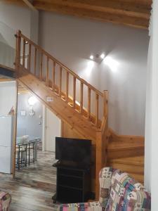 a living room with a staircase and a tv at Apartamentos Santa Justa in Ubiarco