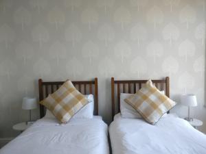 two beds with pillows sitting next to each other at The Beckett Guest House in York