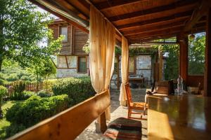 eine Veranda eines Hauses mit einem Tisch und Stühlen in der Unterkunft Gramatikova House in Brŭshlyan