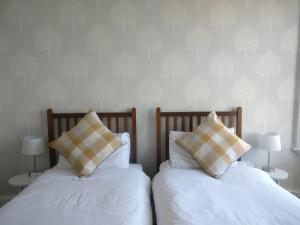 2 camas con almohadas juntas en The Beckett Guest House, en York