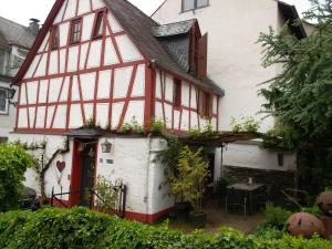 Biały i czerwony dom z czerwonymi drzwiami w obiekcie Ferienhaus-Barz w mieście Treis-Karden