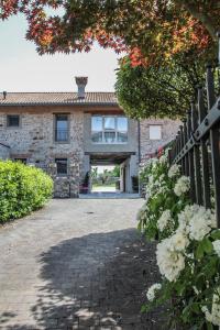 a stone house with a gate and a driveway at Al Sa di Te in Udine