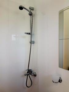 a shower in a white bathroom with a mirror at Belvedere Apartments in Byala +60 photos