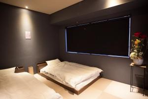 a bedroom with two beds and a large window at Oyama TABI-NE in Kanazawa