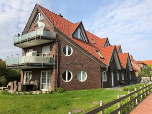 une grande maison avec un toit orange dans l'établissement Winkelschiffchen I mit Sauna, à Juist