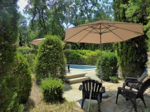 a patio with an umbrella and chairs and a pool at La Bergerie De Vaison in Entrechaux +6 photos