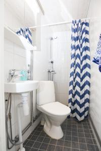 a white bathroom with a toilet and a sink at Cozy studio near University of Turku in Turku
