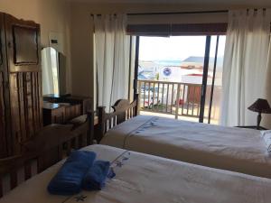 a bedroom with two beds and a balcony with a view at Fairview Accommodation in Gansbaai