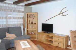 uma sala de estar com um sofá e uma televisão numa mesa de madeira em Ferienwohnung Bergler em Trins