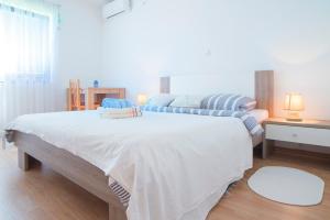 a bedroom with two beds and a table with two lamps at Apartment Ante in Slunj