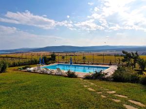 a swimming pool in the middle of a field of grass at Belvedere Apartments in Byala