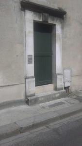 una puerta verde al lado de un edificio en Appartement Dumas, en Bayeux